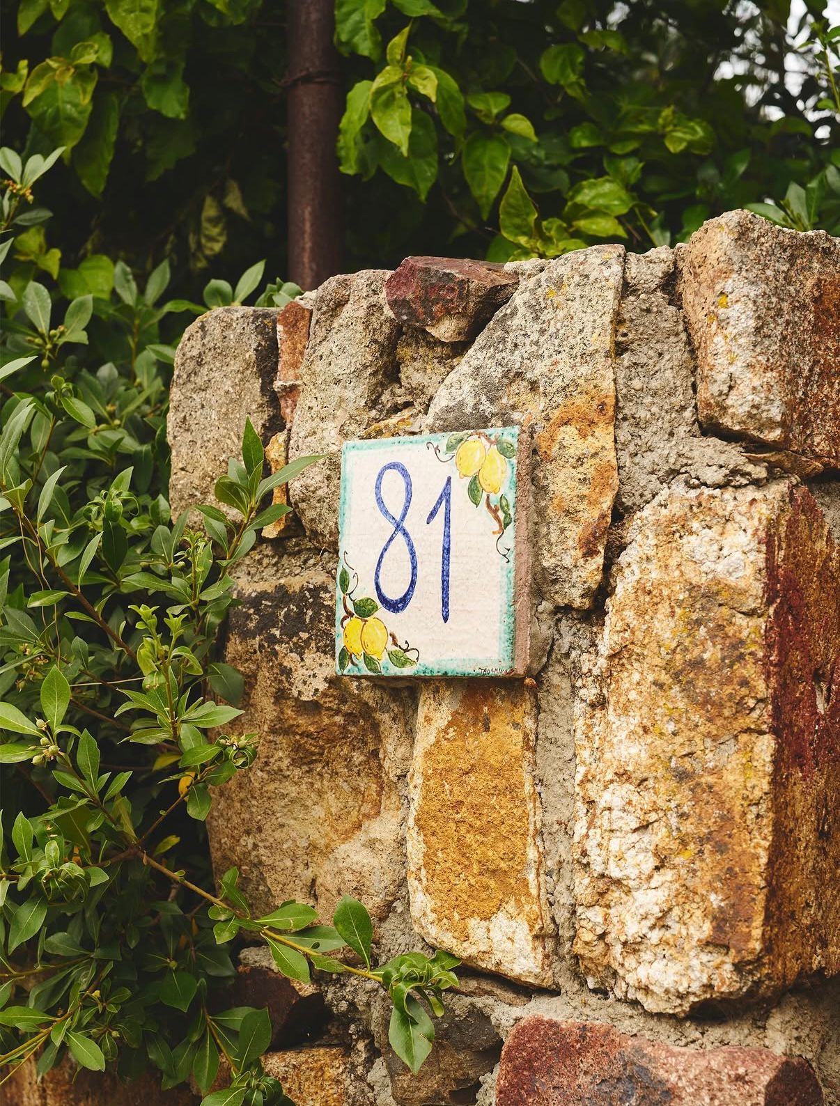 Hand-painted '81' tile on the stone wall