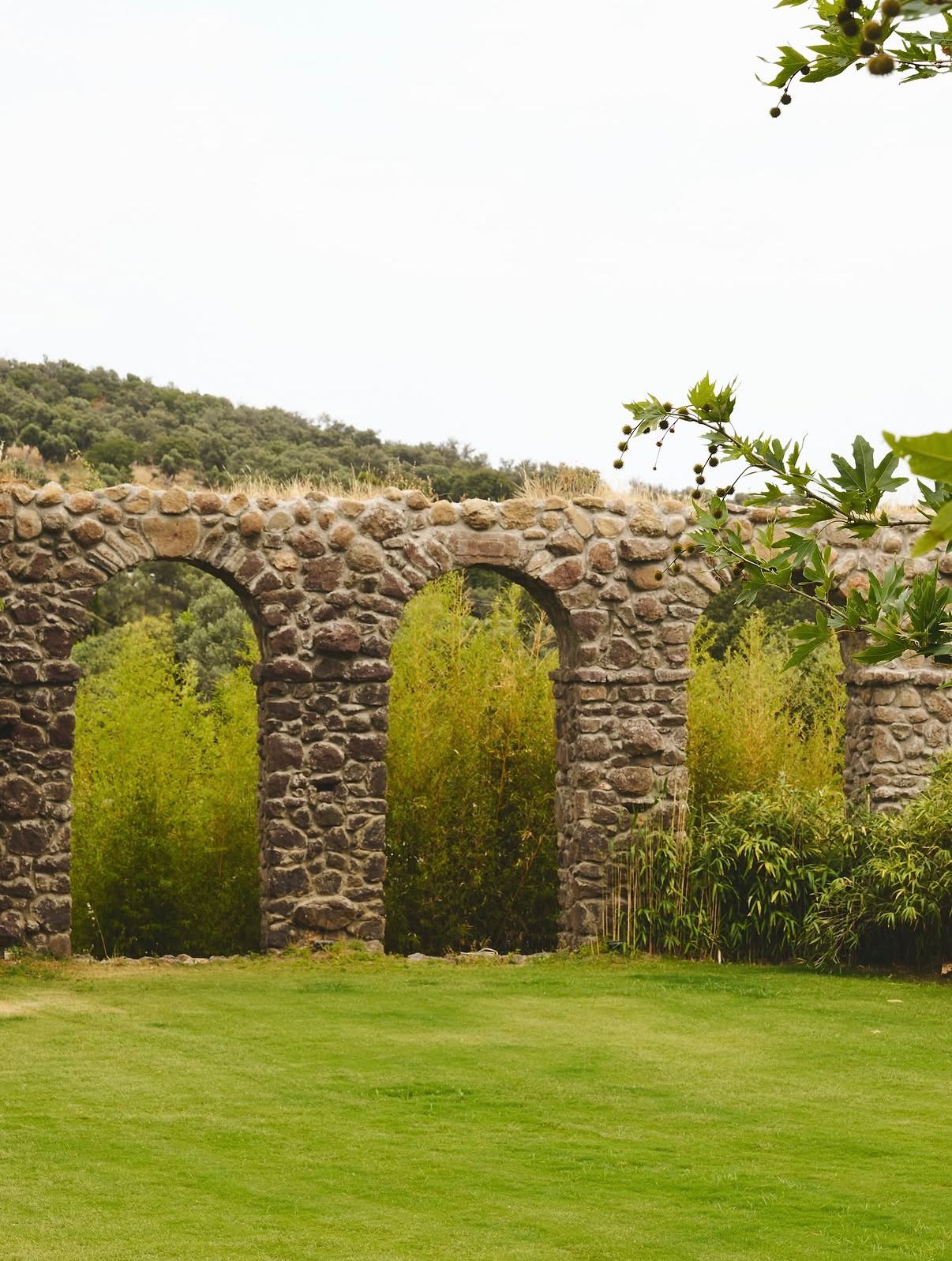 Stone aqueduct arches above the lawn