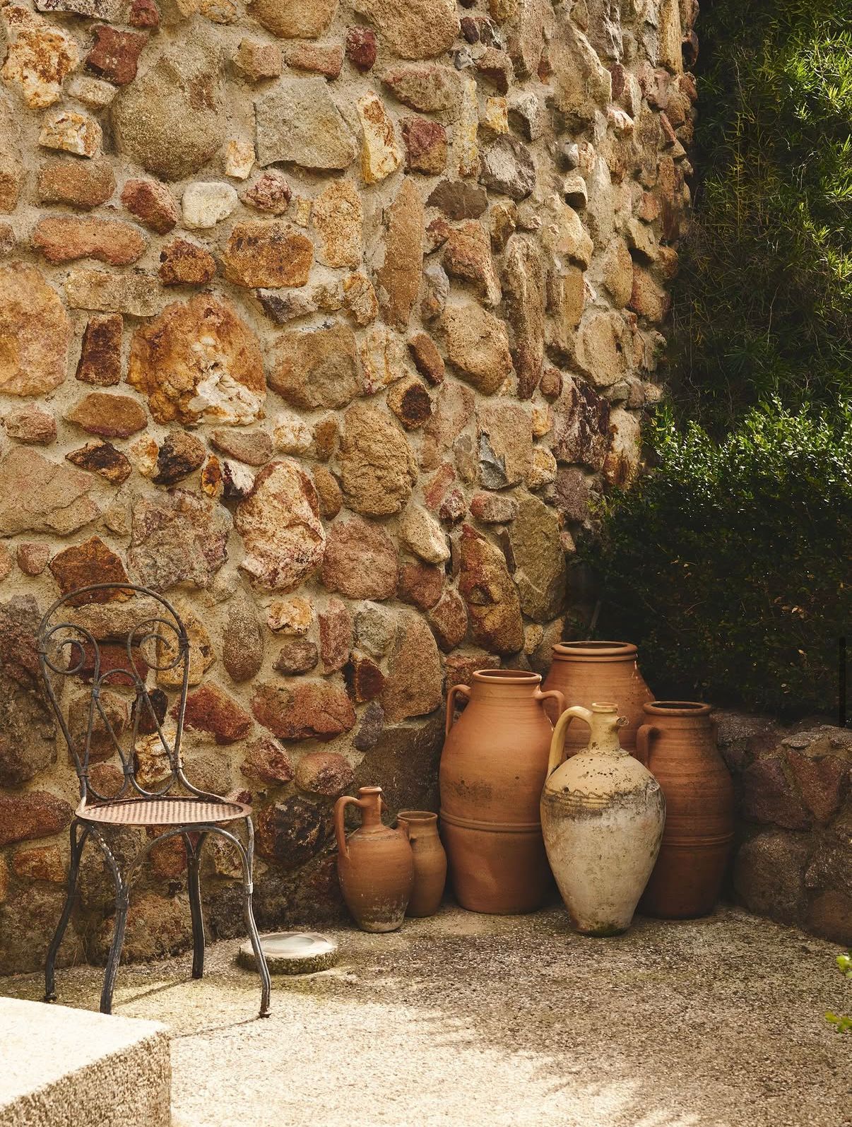 Terracotta amphorae against the stone wall